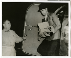Photograph of Howard Hughes and Lockheed 14 airplane, July 5, 1938