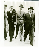 Photograph of Howard Hughes walking with several men, France, July 1938