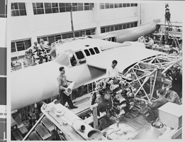 Photograph of airplanes being built by Howard Hughes and workers, circa 1943