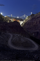 Photograph of a dirt road near Hoover Dam and the arch of the Mike O'Callaghan-Pat Tillman Memorial Bridge under construction, Nevada-Arizona border, June 30, 2009