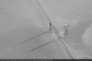 Photograph of new transmission line construction parallels existing transmission lines across dry lake bed, February 3, 2014