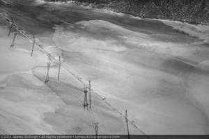 Photograph of new and old tranmission lines leading away from Ivanpah Solar across a dry lake bed, September 24, 2014