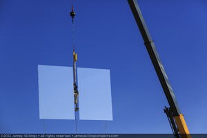 Photograph of heliostat lifted in the air by crane for installation, June 4, 2012