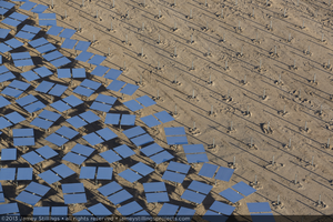 Photograph of heliostats and pylons awaiting heliostats from Unit 3 power tower, September 30, 2013