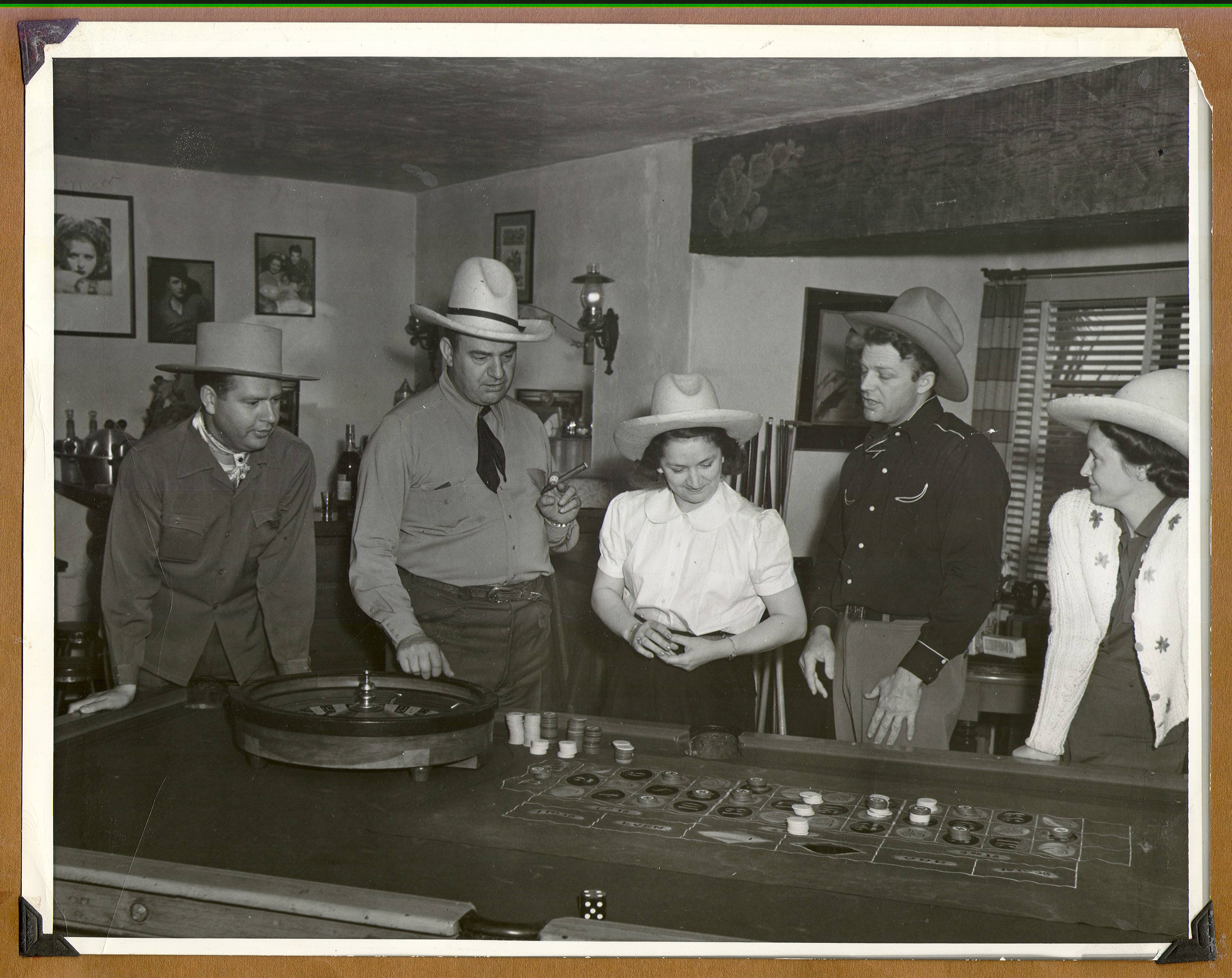 Rex Bell, 2nd from right, Bill Frolicki, and two other couples standing by a roulette wheel: photographic print