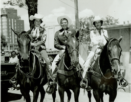 Rex Bell (George Francis Beldam) on horseback with two women in a parade. Stamped on back: Gross Photo, Hotel Mapes, Reno, NV