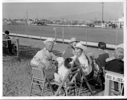 Rex Bell (George Francis Beldam) petting a dog at a horse event. Stamped on back: Compliments of Lieutenant Governor, Harold J. Powers, Sacramento, California
