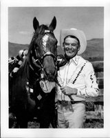 Rex Bell (George Francis Beldam) next to a horse at unknown location. Stamped on back: Gross Photo, Hotel Mapes, Reno, NV