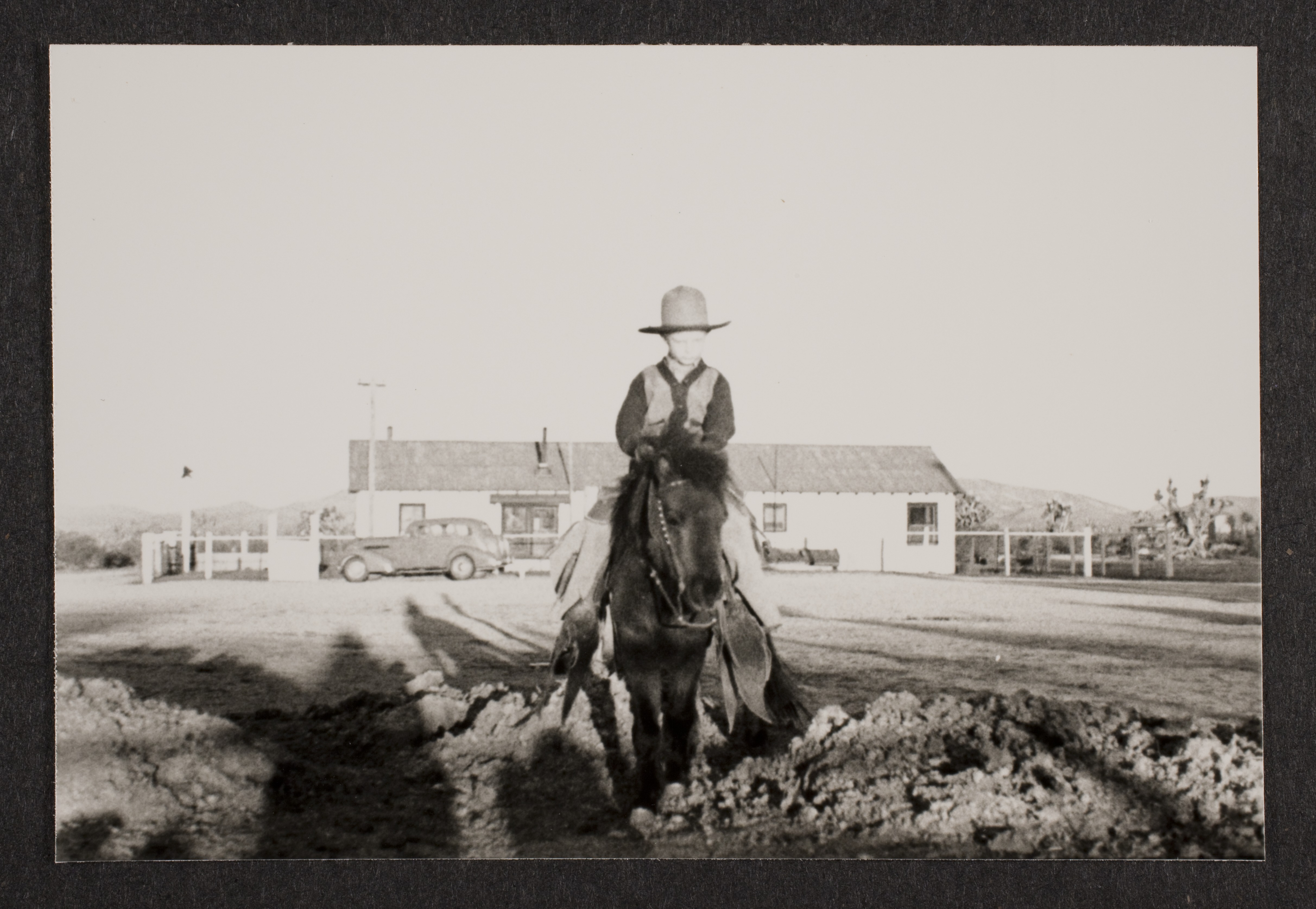 Rex Jr. (Toni) on pony (Smoky) in front of the bunkhouse at Walking Box Ranch, Nevada: photographic print