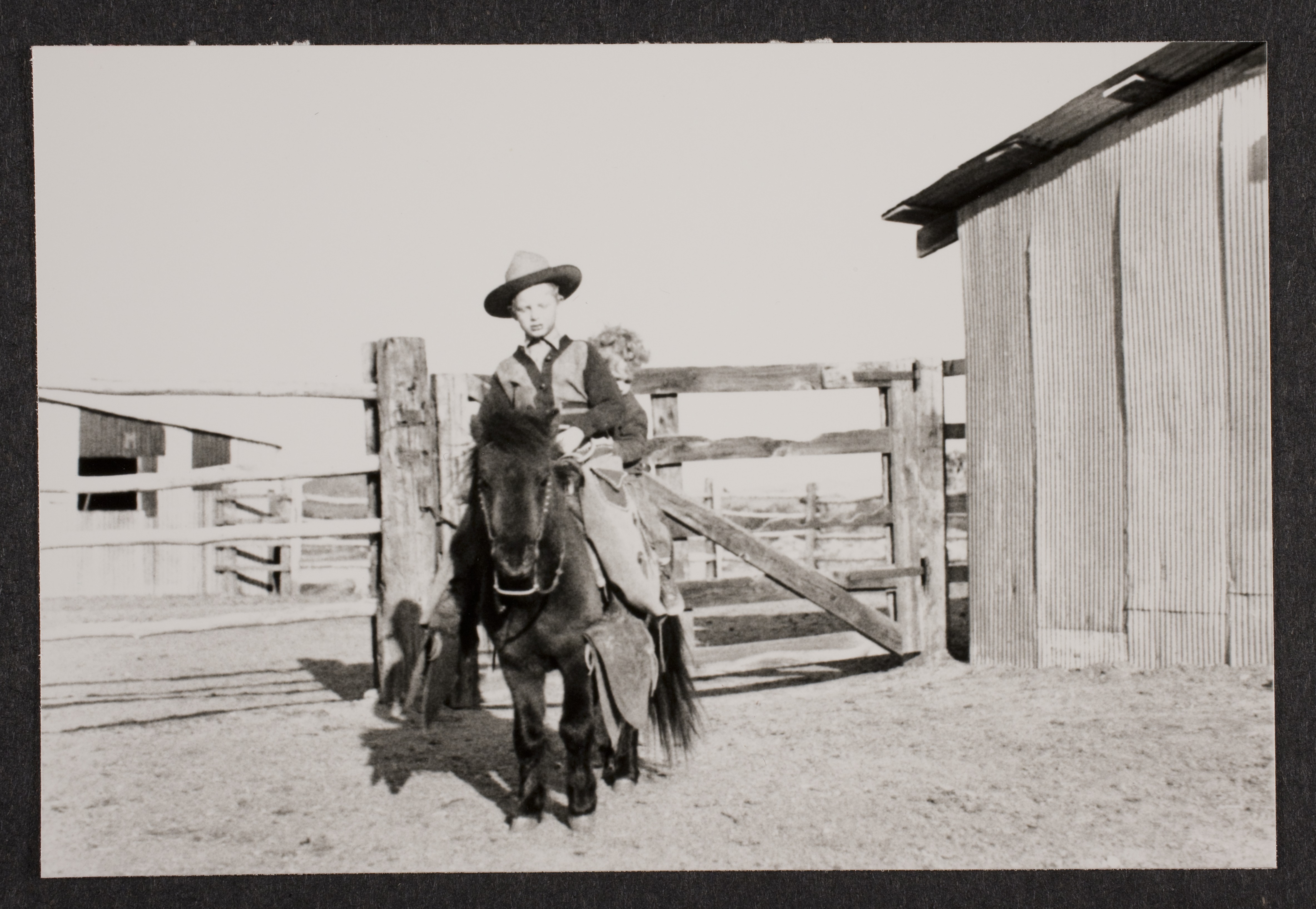 Rex Jr. (Toni) on pony (Smoky) in barn area at Walking Box Ranch: photographic print