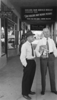 Film transparency of men in front of the Boulder Dam Service Bureau, Boulder City, Nevada, circa 1932-1940