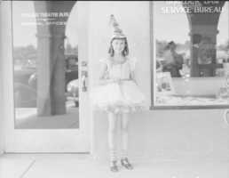 Film transparency of a girl outside Boulder Dam Service Bureau Building, Boulder City, Nevada, circa 1930s-1940s