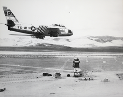 Black-and-white photograph of an F-86 fighter aircraft at Nellis Air Force Base near Indian Springs, Nevada, circa mid 1950s