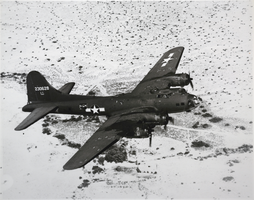 Black-and-white photograph of a Boeing B-17 bomber aircraft in flight, Las Vegas Flexible Gunnery School, circa early 1940s