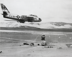 Black-and-white photograph of an F-86F in flight, Nellis Air Force Base, Las Vegas, circa 1950s