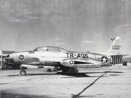 Black-and-white photograph of a Lockheed T-33A trainer aircraft on land, Nellis Air Force Base, Las Vegas, circa 1950s