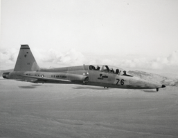 Black-and-white photograph of a Northrop T-38A trainer aircraft in flight, Nellis Air Force Base, circa 1970s
