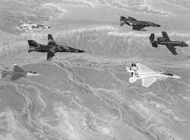 Black-and-white photograph of several fighter aircraft in flight, Nellis Air Force Base, Las Vegas, circa 1970s