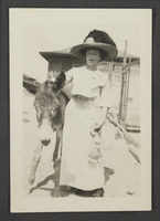 Photograph of Mayme Stocker with a burro, circa 1910s
