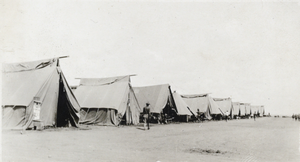 Photograph of a line of tents, circa early 1900s
