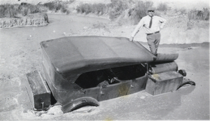 Photograph of man standing on a truck, circa 1910s-1920s