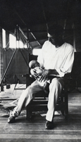 Photograph of a man holding a baby, circa 1920s-1940s