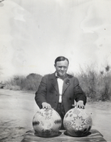 Photograph of a man with Helen Stewart's baskets, circa 1910s
