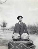 Photograph of a man holding baskets, circa 1910s