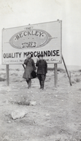 Photograph of people in front of billboard, circa 1900-1920s
