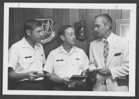 Black-and-white photograph of military personnel receiving a plaque from the United Way, Nellis Air Force Base, Nevada, April 15, 1976