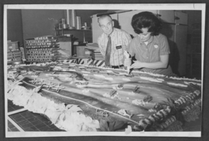 Photograph of a woman decorating a cake for a Christmas party at Nellis Air Force Base, Nevada, December 1976