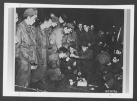 Photograph of Private First Class Robert Brandon rationing bread at a prisoner of war camp during World War II, Germany, 1944