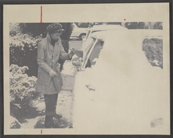 Photograph of a woman cleaning snow off of her car, North Las Vegas, Nevada, 1974