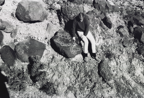 Photograph of a man looking at petroglyphs in Meadow Valley Wash, Nevada, January 1965