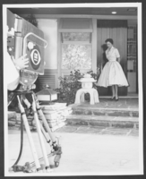 Black-and-white photograph of Toni Clark standing outside the front door of her home, Las Vegas, Nevada, 1957