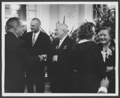 Black-and-white photograph of Russian Premier Nikita Khrushchev and his wife Nina Khrushcheva at a reception, location unknown, 1959
