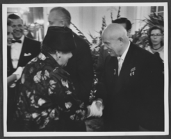 Black-and-white photograph of Nikita Khrushchev shaking hands with a woman at his reception, 1959