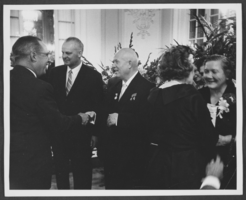 Black-and-white photograph of Russian Premier Nikita Khrushchev and his wife Nina Khrushcheva at a reception, location unknown, 1959