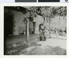 Photograph of Tweed Wilson standing in front of a stone house in Las Vegas, Nevada, circa 1953
