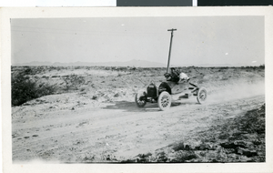 Photograph of a roadster in the desert, circa early 1900s