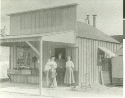 Photograph of the Westlake family in front of a grocery store, 1909.