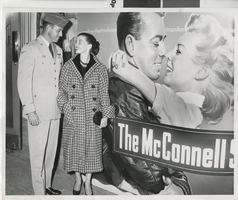 Photograph of a man and women in front of a poster for "The McConnell Story," Las Vegas (Nev.), 1955