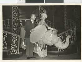 Photograph of a man with a showgirl posing onstage with an elephant costume, Dunes Hotel, Las Vegas (Nev.), 1957-1960s