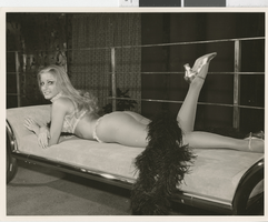 Photograph of a showgirl posing on a chaise lounge, 1960s