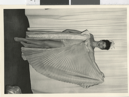 Photograph of a showgirl in a costume with a long pleated drape, Dunes Hotel, Las Vegas (Nev.), 1957-1960s