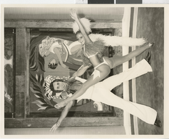 Photograph of two Minsky's Burlesque cast members in front of a painted wooden set piece, Playboy Hotel, Chicago (Ill.), circa 1977