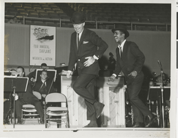 Photograph of Peter Lawford and Sammy Davis, Jr., dancing onstage during a Four Immortal Chaplains benefit at the Las Vegas Convention Center, February 7, 1960