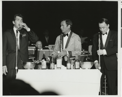 Photograph of Joey Bishop serving drinks to Dean Martin and Frank Sinatra onstage at the Sands, Las Vegas, April 1966