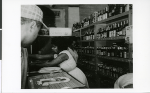 Photograph of "Mrs. Bruno's daughter" tending Bruno's Liquor Store