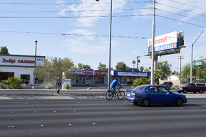 Bicyclist and cars on West Sahara Avenue at Richfield Boulevard looking south, Las Vegas, Nevada: digital photograph
